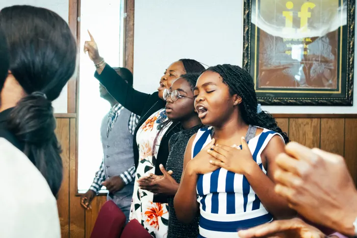 Members of Victory House singing and praying