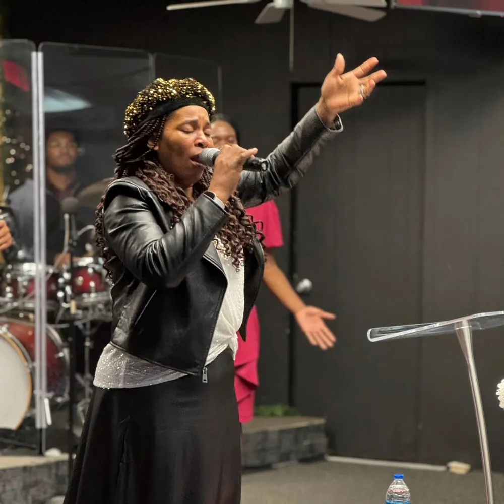 A woman leading worship at Victory House