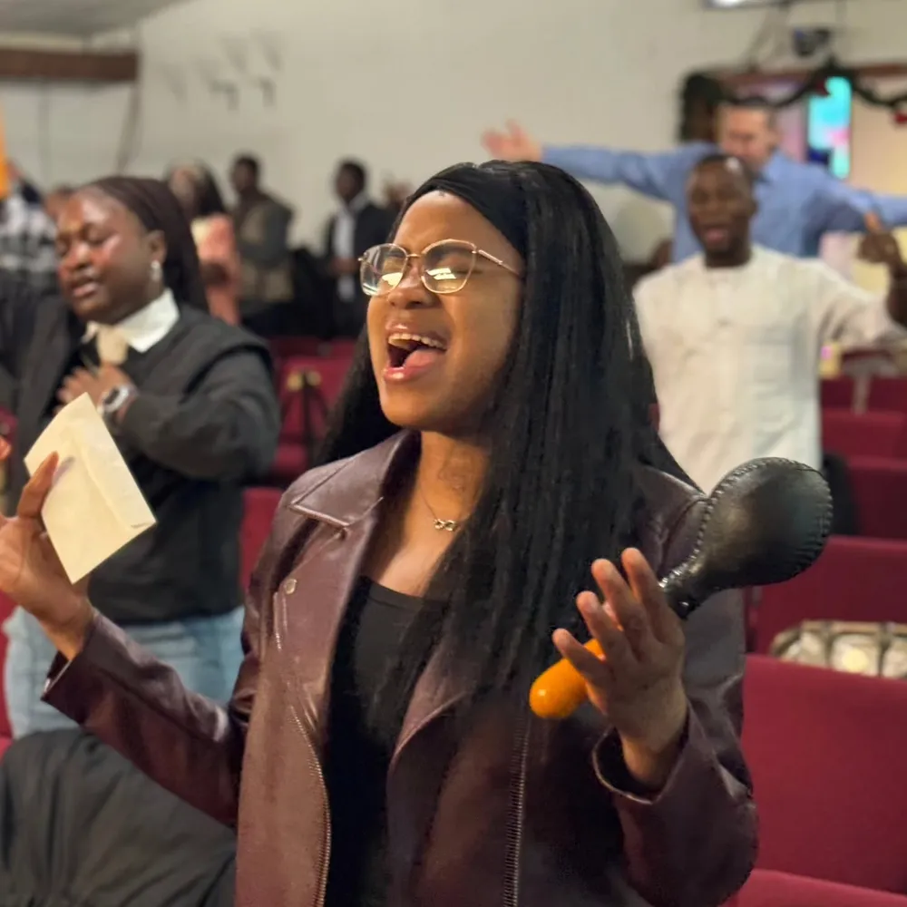 A woman worshipping during a Victory House service